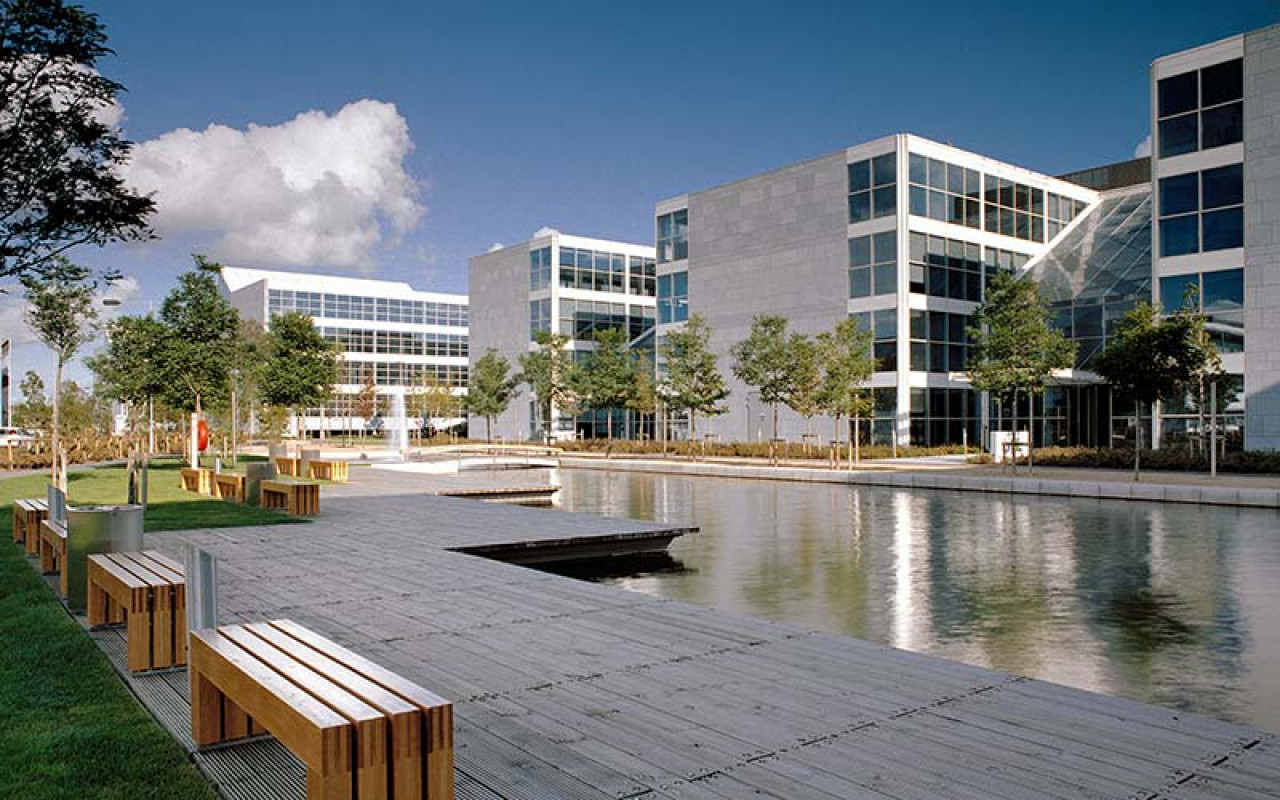 Exterior of office buildings with a large pond